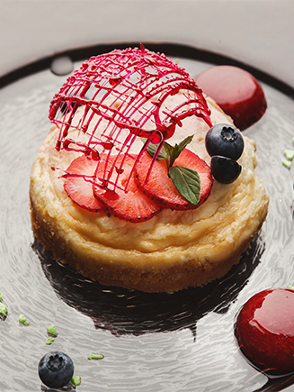 Lemon cheesecake with berry spheres served at modern restaurant