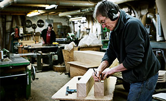a man working in a furniture maker workshop